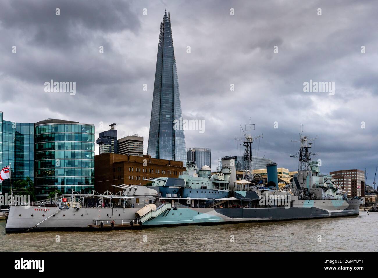 Die HMS Belfast liegt an der Themse vor dem Hintergrund des Shard, London, Großbritannien. Stockfoto