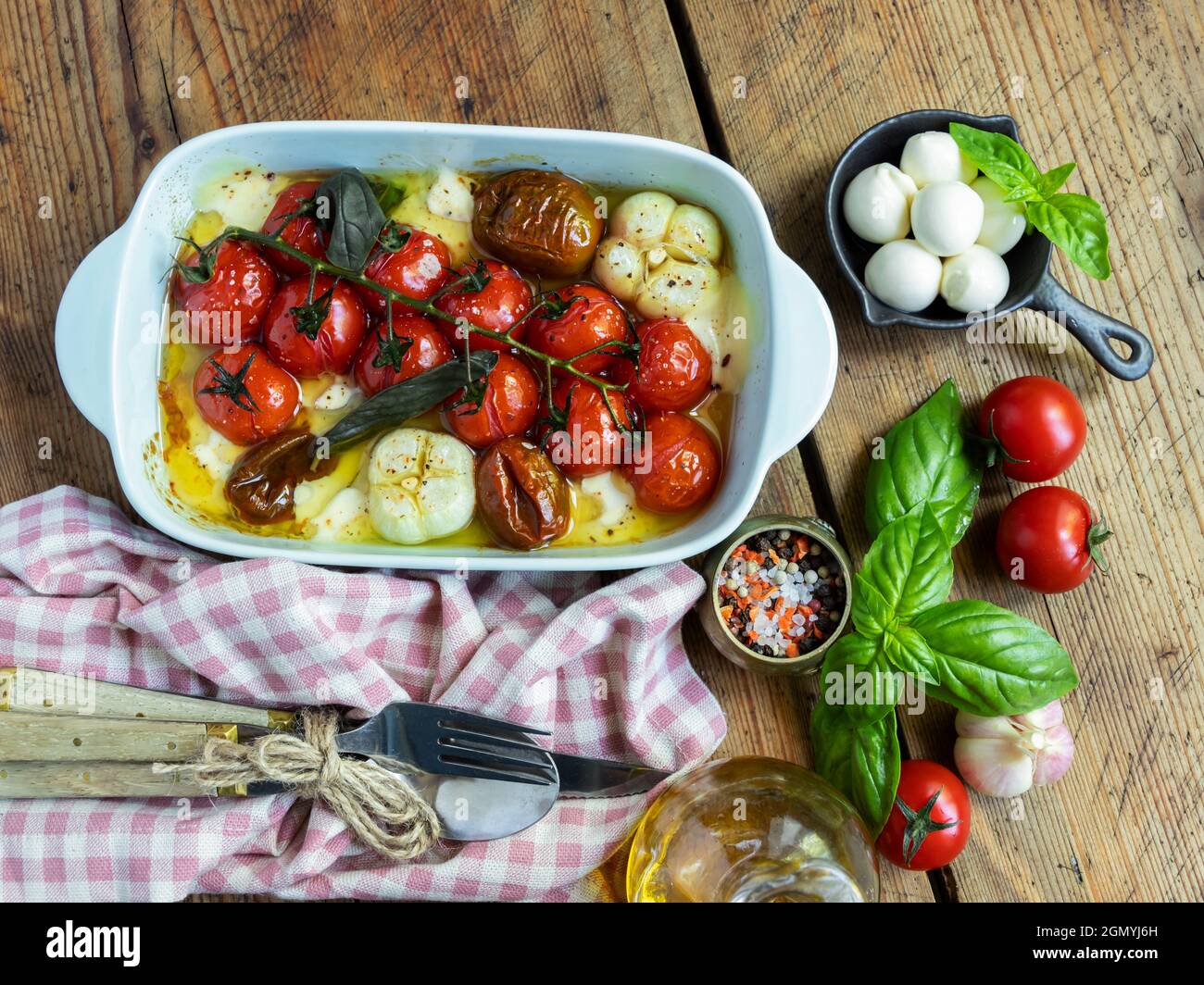 Gebackene Gemüsestomate, Basilikum, Mozzarella-Käse, Knoblauch im Ofen in keramischen Gerichten. Kochen, gekochtes Gericht. Stockfoto