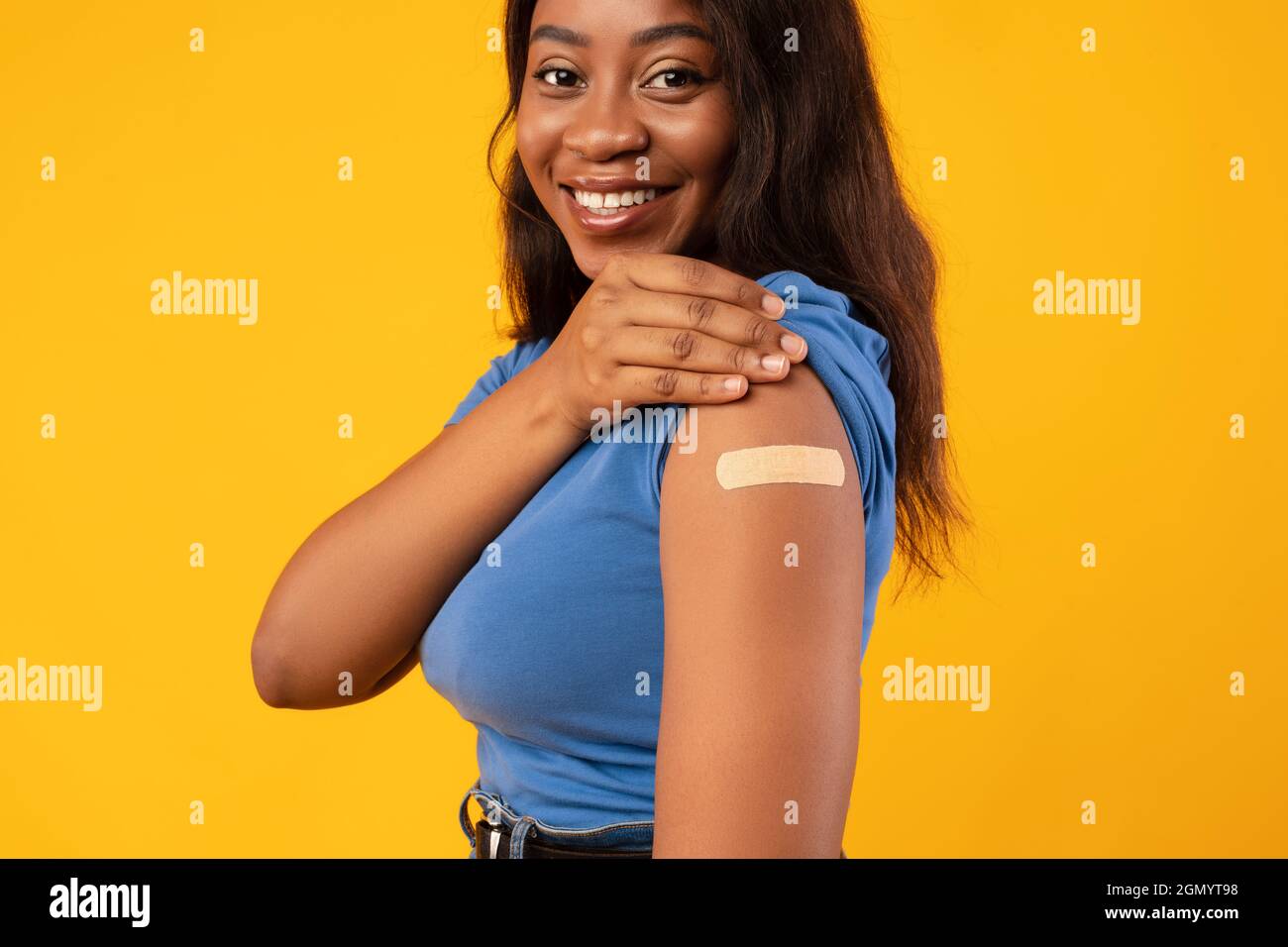 African American Lady Zeigt Geimpften Arm, Gelber Studiohintergrund, Abgeschnitten Stockfoto