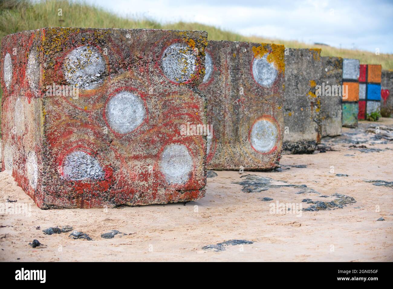 Große Betonblöcke, die als Panzerabwehr im zweiten Weltkrieg verwendet werden und als Würfel oder rubik-Würfel lackiert sind. Stockfoto