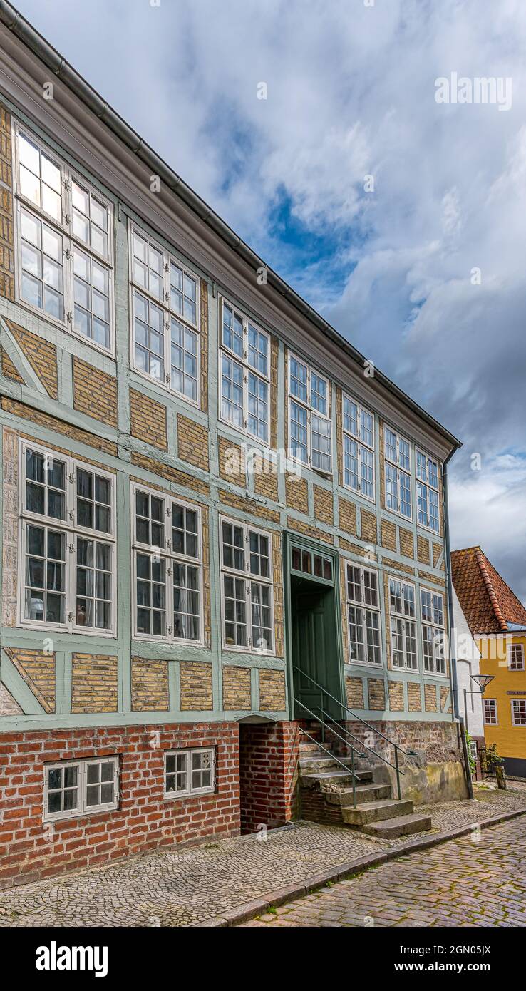 Fachwerkhaus mit großen Fenstern in der Fassade mit Spiegelungen des blauen Himmels, Haderslev, Dänemark, 26. August 2021 Stockfoto