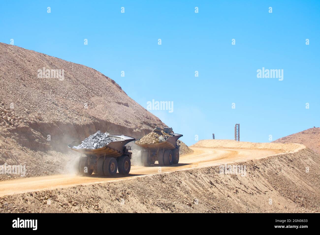 Riesige Muldenkipper, die mit Mineralien in einer Kupfermine in Chile beladen sind. Stockfoto