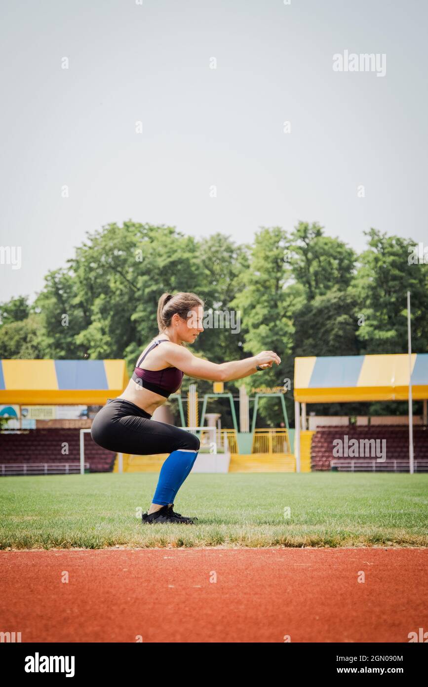 Junge athletische Frau streckt und bereitet sich auf das Laufen vor. Starke Sportfrau Stockfoto