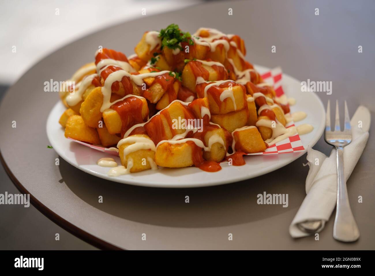 Kartoffelchips mit heißer Sauce in Spanien serviert Stockfoto