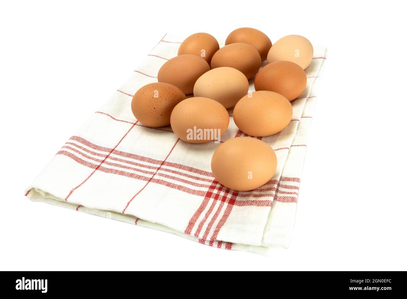 Frische Hühnereier auf weißem Hintergrund. Tonschüssel mit braunen Eiern auf einem Handtuch. Hintergrund mit Kopierbereich Stockfoto