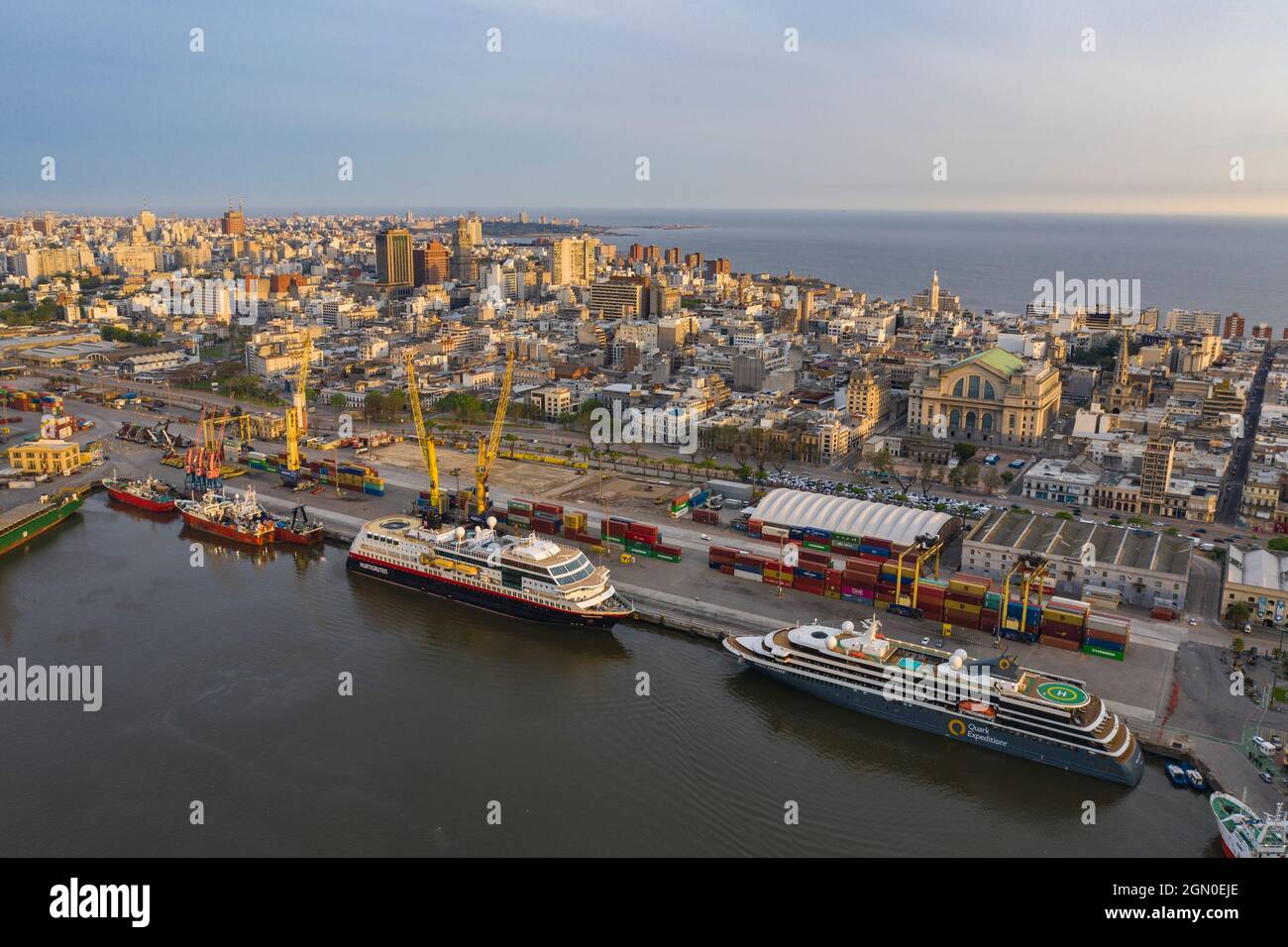 Luftaufnahme der Expeditionskreuzschiffe Midnatsol (Hurtigruten Cruises) und World Explorer (Nicko Cruises) mit der Skyline der Stadt bei Sonnenaufgang, Punta d Stockfoto