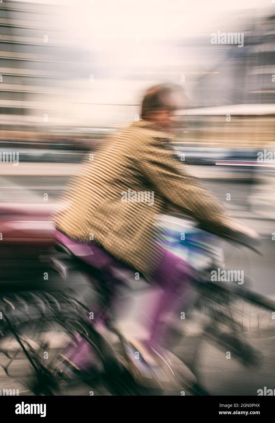 Dynamische Aufnahme eines Radfahrers, der durch die Straßen Berlins in Deutschland fährt, verwischt mit einer Zoom-Burst-Technik Stockfoto