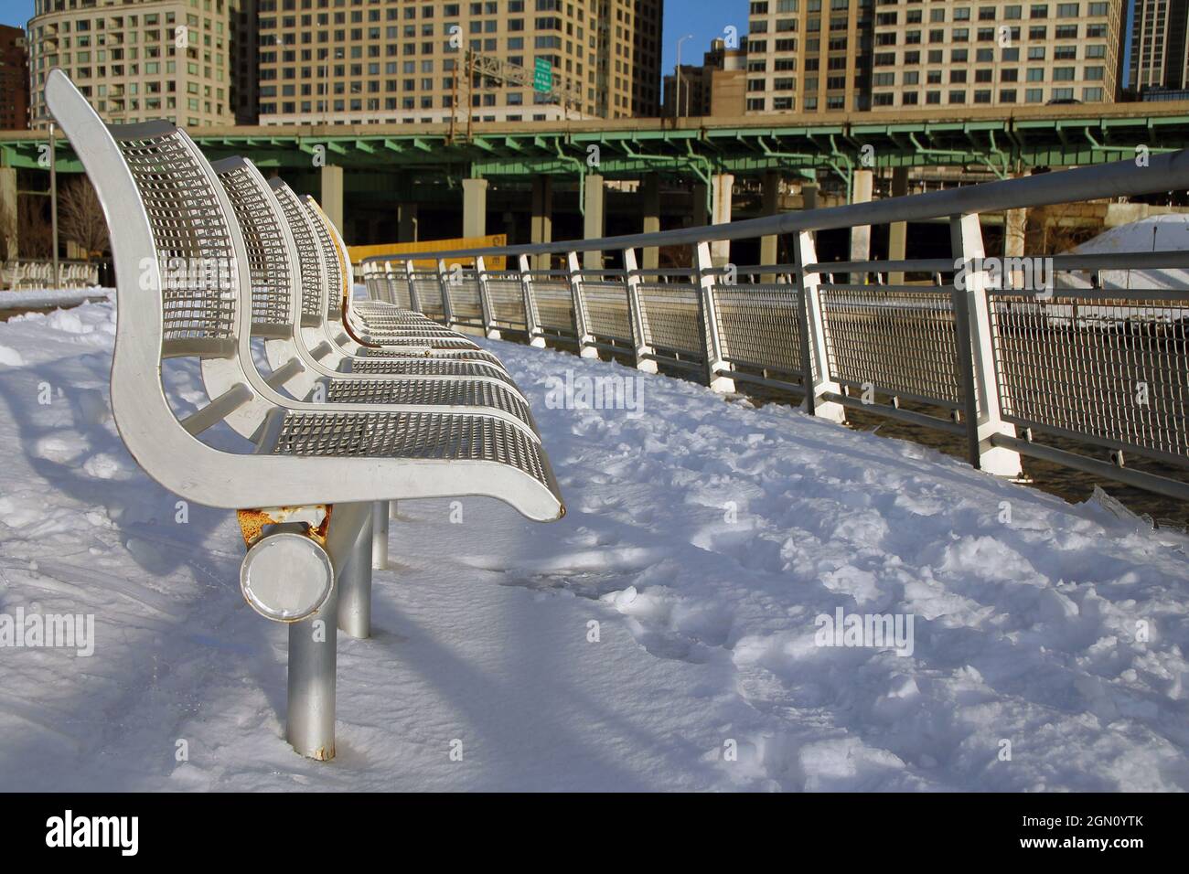 Die Bänke, der Schnee, der Fluss, die Autobahn und die Wolkenkratzer in New York City Stockfoto