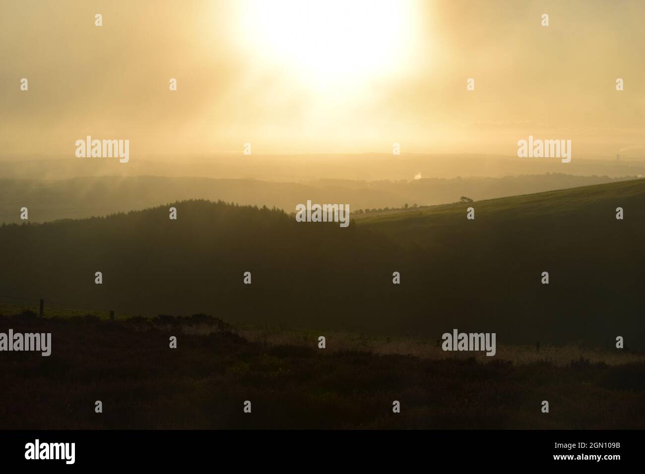 Sonnenaufgang durch den frühen Morgennebel über der Clwydian Range North Wales. Stockfoto