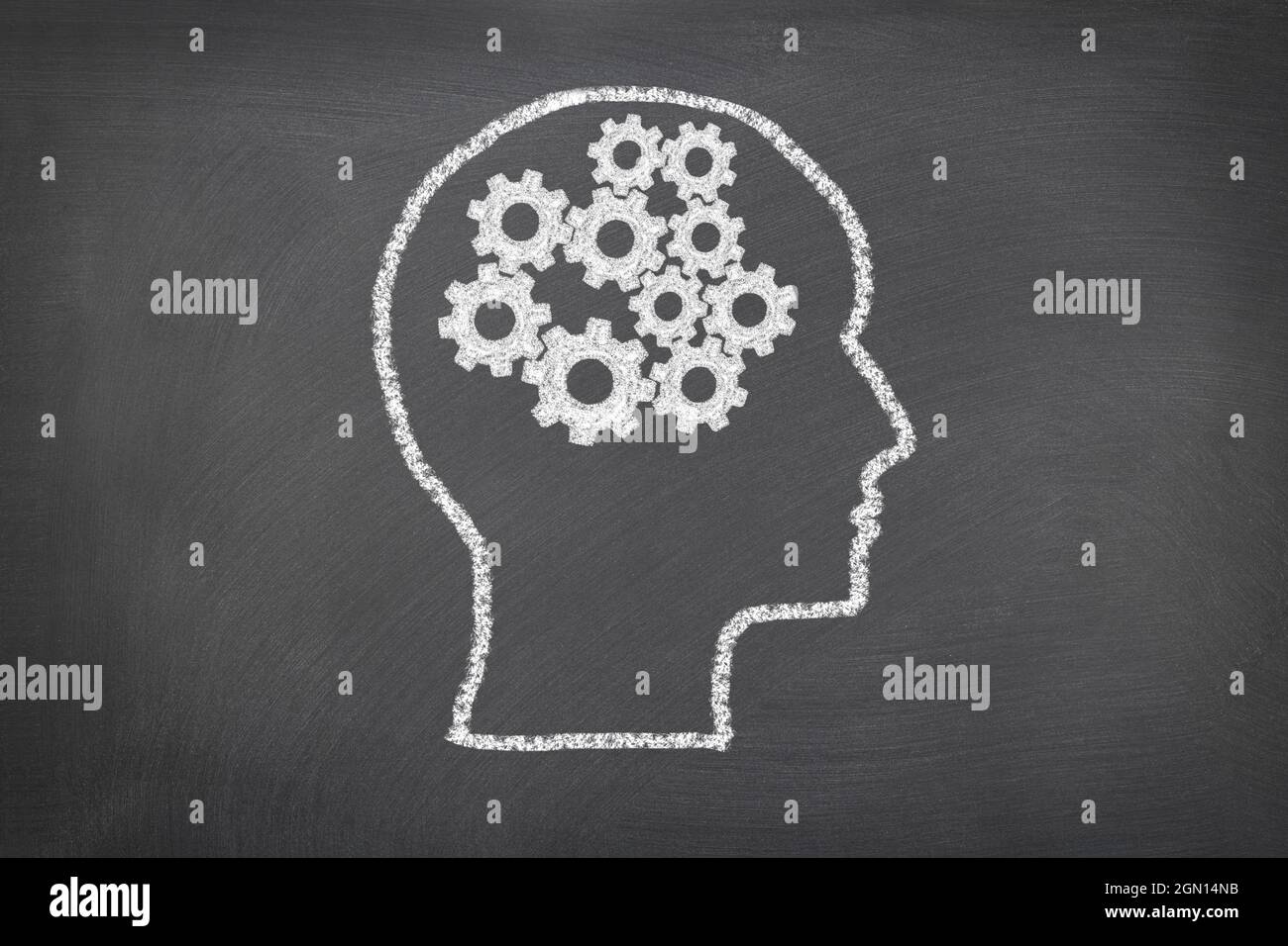 Eine Kreideskizze auf einer Tafel mit einem menschlichen Kopf und Zahnrädern, die Gedanken darstellen, für die Verwendung als jedes wissenschaftliche Thema oder zur Betrachtung des Denkens des Menschen. Stockfoto