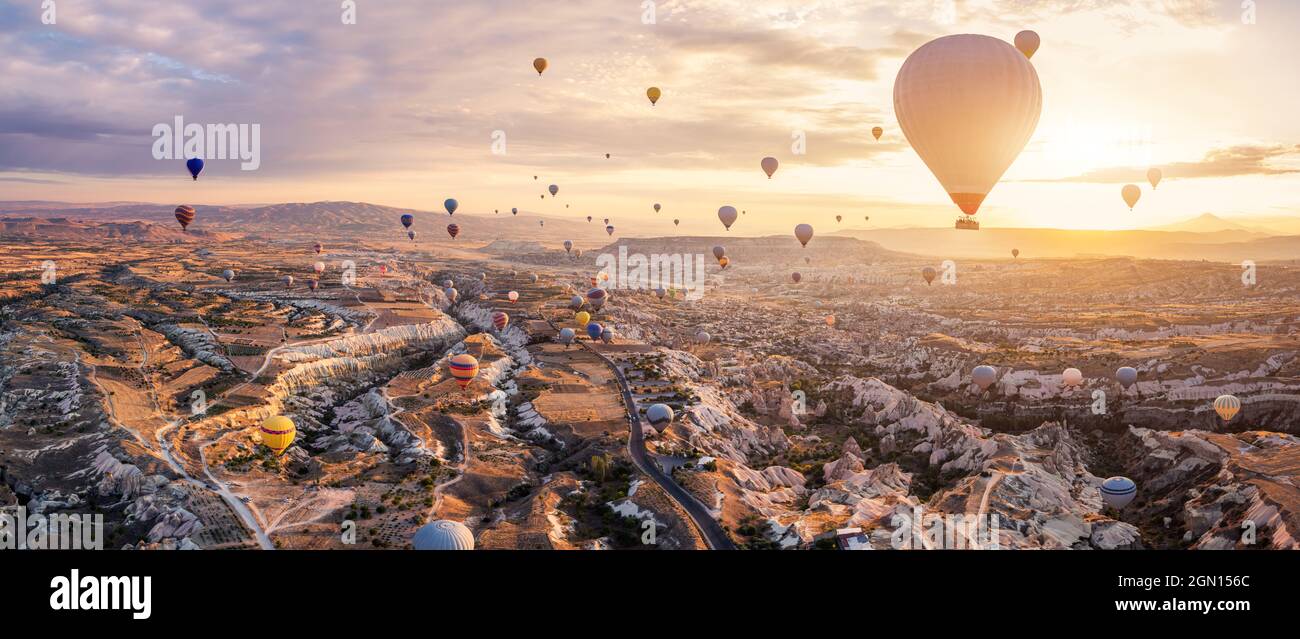 Heißluftballons fliegen über Göreme, Kappadokien (Kapadokya) Anatolien, Türkei bei Sonnenaufgang. Panoramablick auf Dörfer und Feenkamine. Beliebte Touri Stockfoto