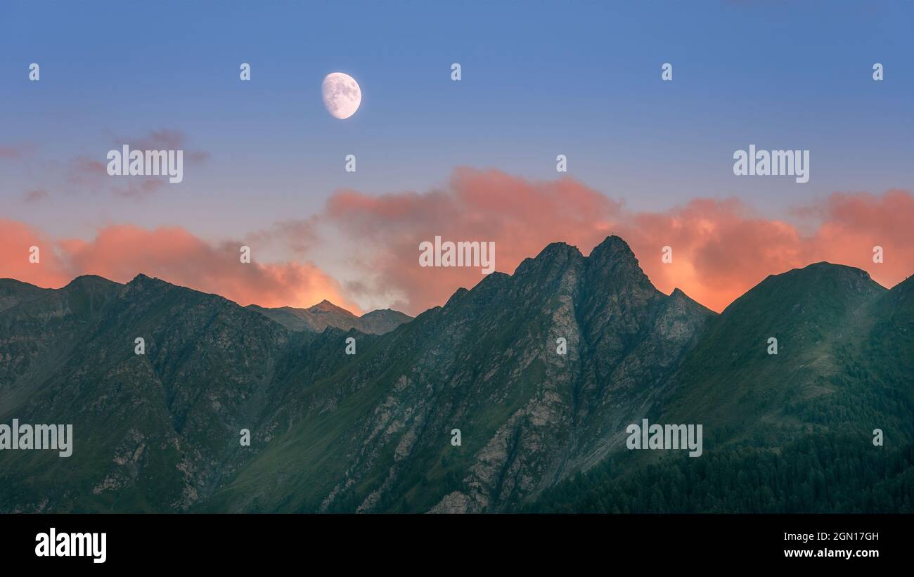 Bei Sonnenuntergang in der Region Serfaus Fiss Ladis erhebt sich der Mond über den österreichischen alpen Stockfoto