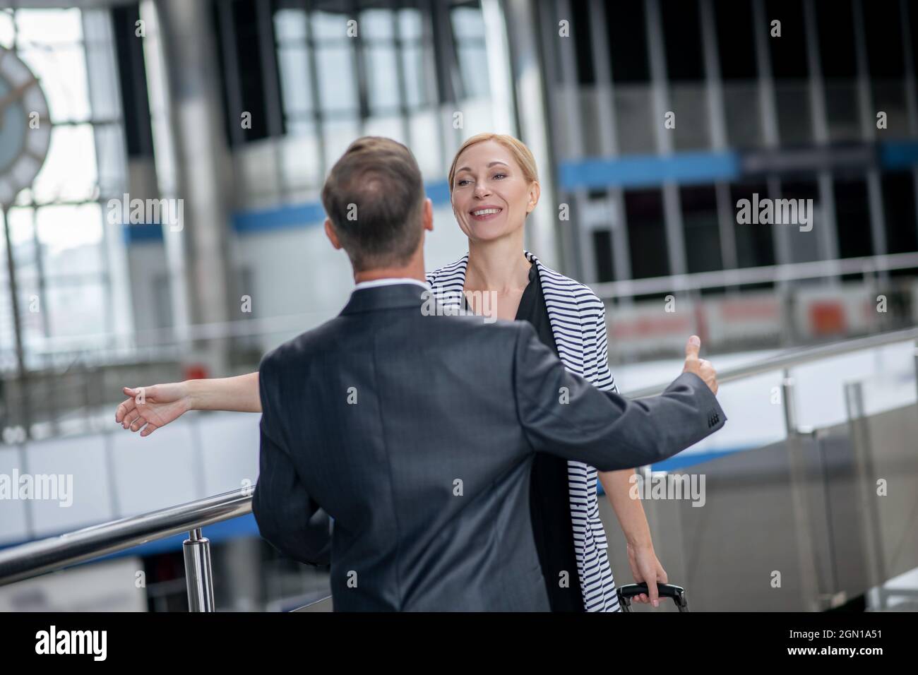 Fröhliche Frau und Rücken der Mann zu treffen Stockfoto