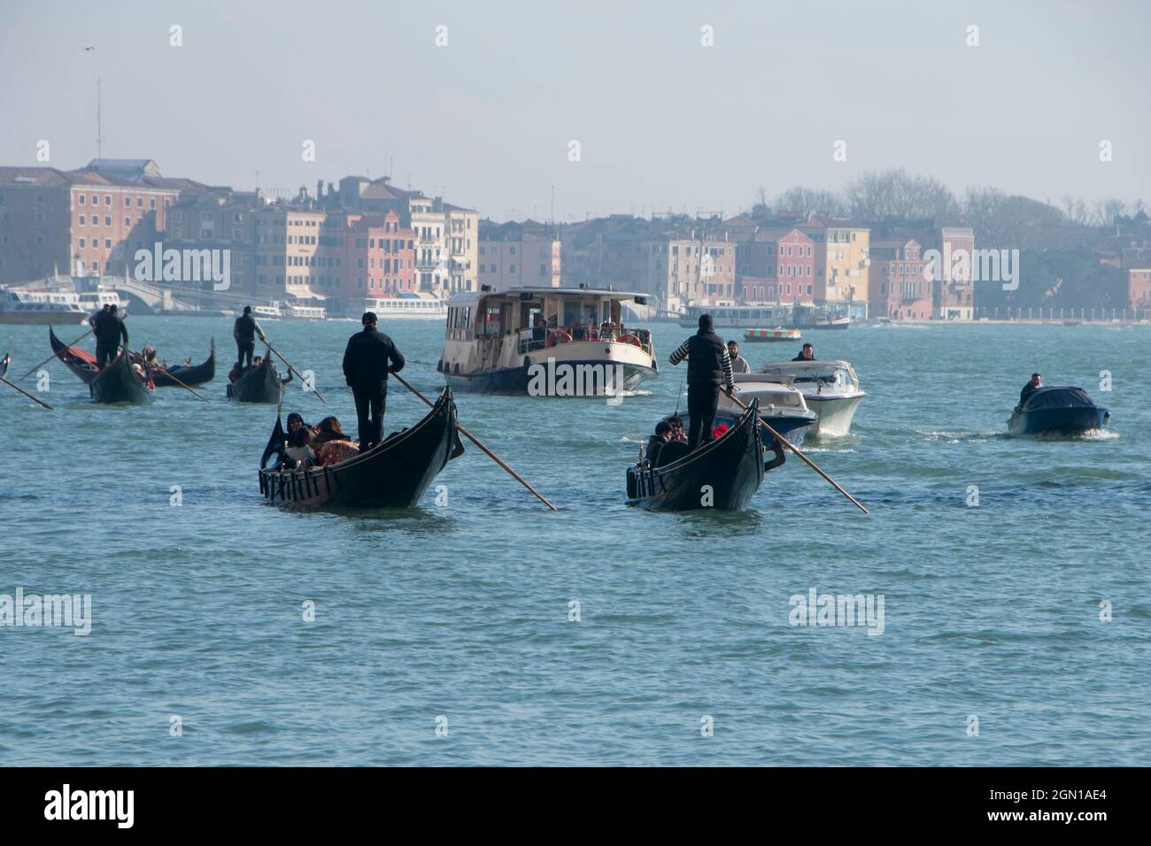 Fähren, Motorboote und Gondeln mit Touristen fahren durch die Lagune von Venedig vor dem Markusplatz, Italien. Stockfoto