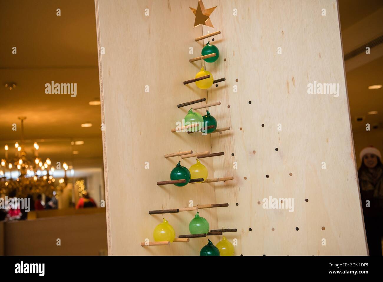 Geometrische Skulptur Weihnachtsbaum mit grünen und gelben Glühbirnen. Stockfoto