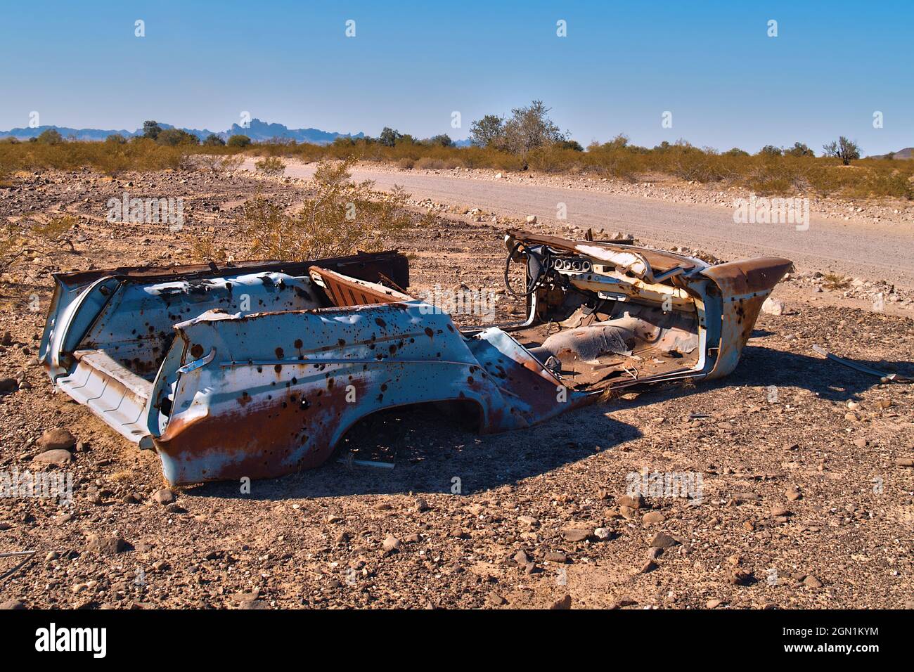 Die gespenstische Hülle eines alten Autos, das auf einer unbefestigten Straße in einem abgelegenen Gebiet im Westen von Arizona liegt. Stockfoto
