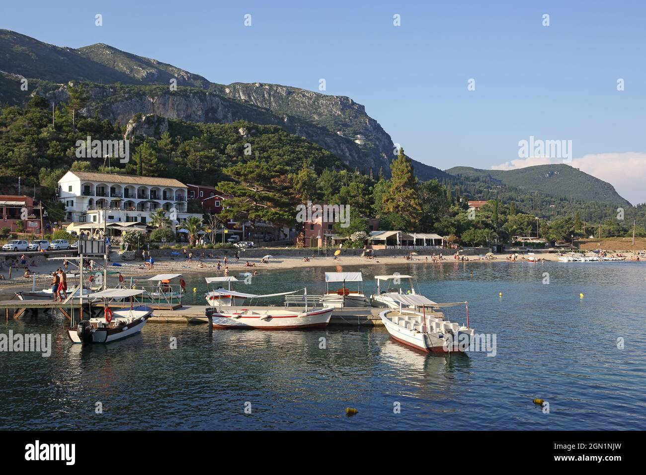Der Strand von Agios Spiridon in Paleokastritsa liegt zwischen zwei Halbinseln. Ausflugsboote starten vom Pier, Korfu Insel, Ionische Inseln, Gr Stockfoto