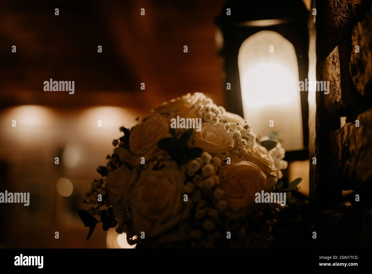 Dunkles Licht Bouquet von Rosen und Lampe Stockfoto