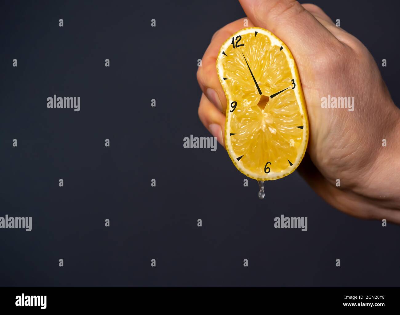 Die Hand drückt eine Zitrone aus, auf die die Uhr gezogen wird  Stockfotografie - Alamy