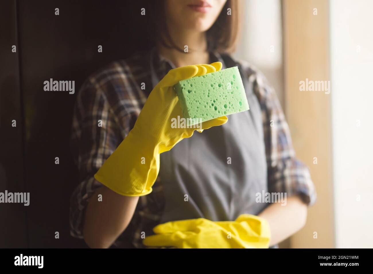 Eine Frau in gelben Gummihandschuhen macht Hausarbeit Stockfoto