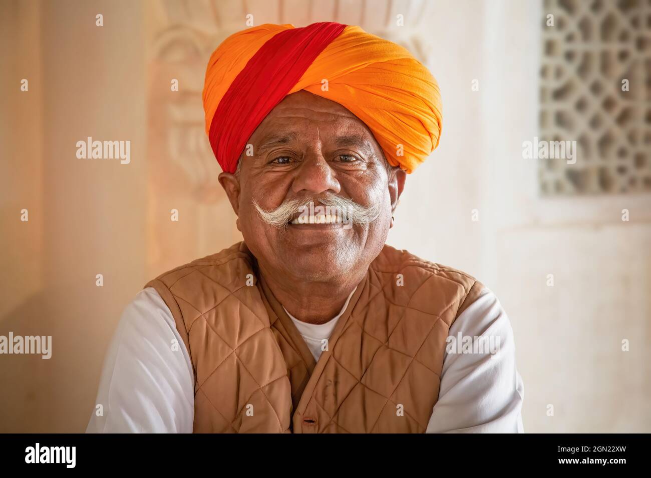Gealterter Rajasthani-Mann mit traditionellem Schnurrbart, der einen Safranturban in Nahaufnahme im Mehrangarh Fort, Jodhpur, Rajasthan, Indien trägt Stockfoto