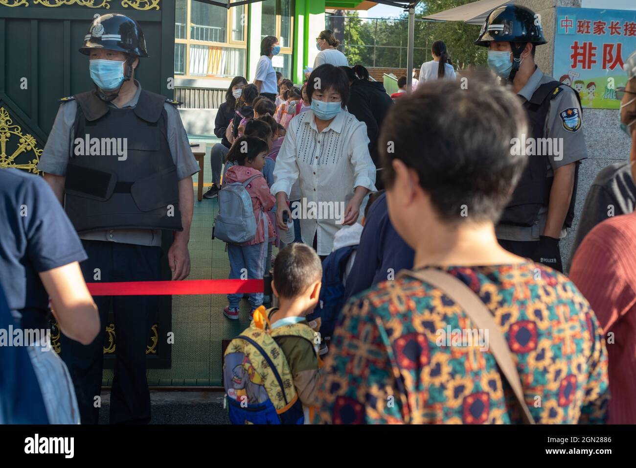 Zwei Sicherheitskräfte bewachen den Eingang eines Kindergartens in Peking, China. 22-Sep-2021 Stockfoto