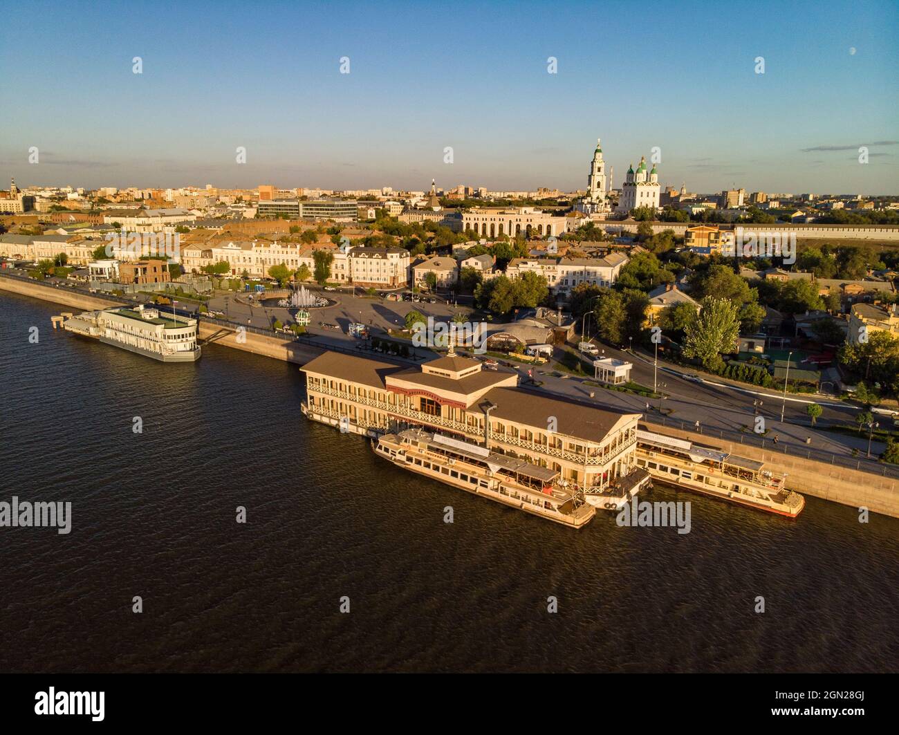 Luftaufnahme von Ausflugsbooten und schwimmenden Restaurant entlang der Promenade am Ufer der Wolga mit Astrachan Kreml hinter, Astrachan, Astrachan Distr Stockfoto