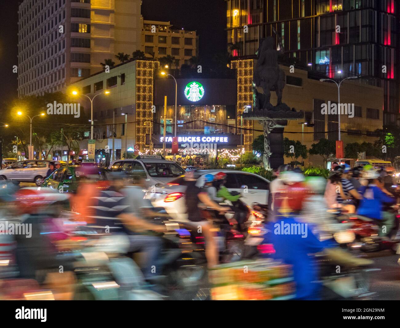 Starker Verkehr in der Nacht vor dem ab Tower Starbucks Coffee - Ho Chi Minh City, Vietnam Stockfoto