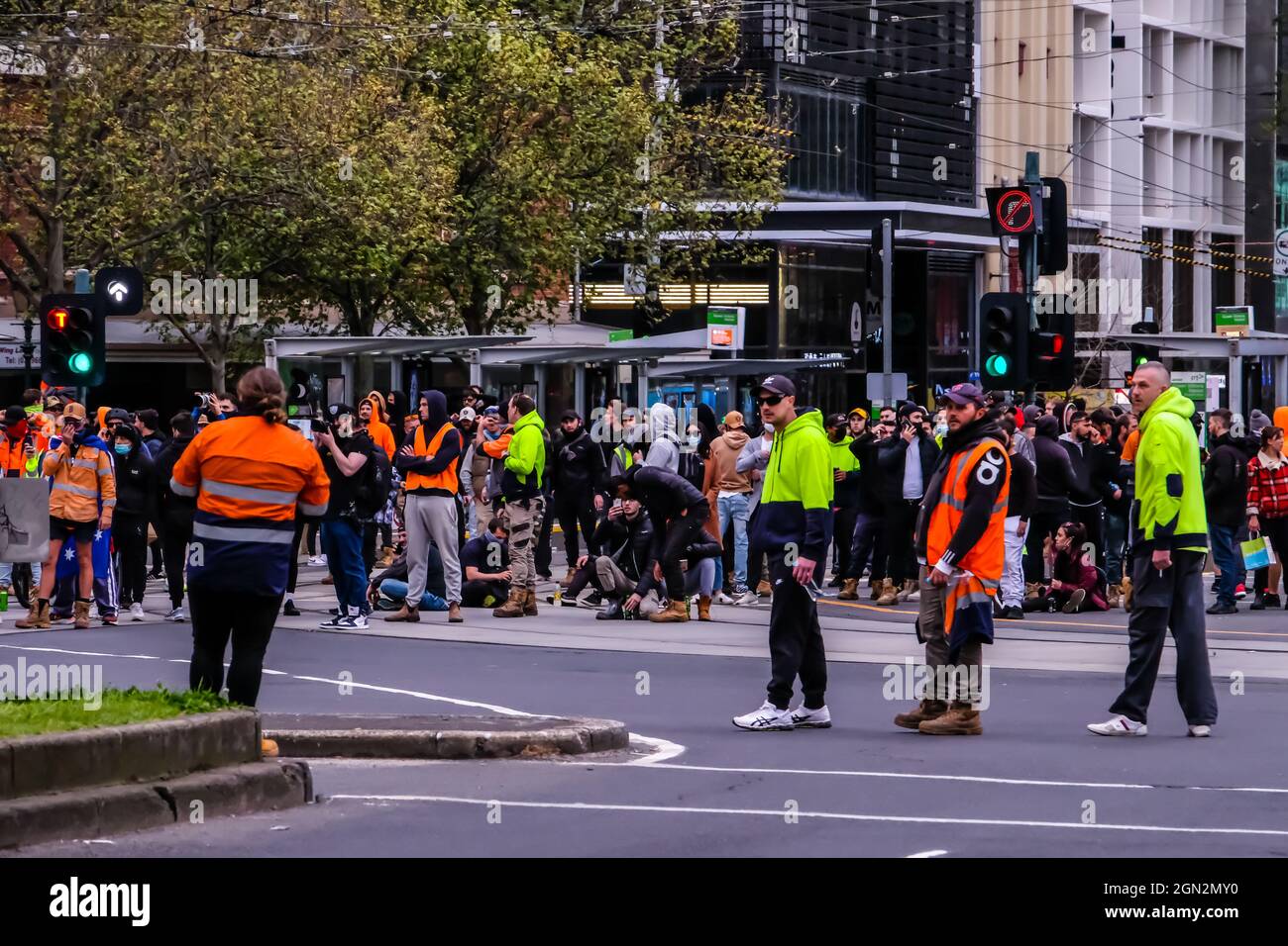 Während der Demonstration blockierten Demonstranten die Straße.Gestern um 5-6 Uhr fand an der Ecke Victoria Street und Elizabeth Street im Geschäftsviertel von Melbourne eine Fortsetzung der Pattsituation zwischen der Polizei von Victoria und den Demonstranten der Bauindustrie statt. Die Arbeiter protestieren gegen die obligatorische Impfung der Industriemitglieder sowie gegen die 2-wöchige Sperrung der gesamten Industrie durch die viktorianische Regierung. Rund 500 starke Polizisten mit Anti-Riot-Einheit und berittener (Pferde-)Einheit kamen zusammen mit der allgemeinen Polizei, um die Demonstranten in voller Aufstandsausrüstung mit Spezialausrüstung wie peppe zu vergelten Stockfoto