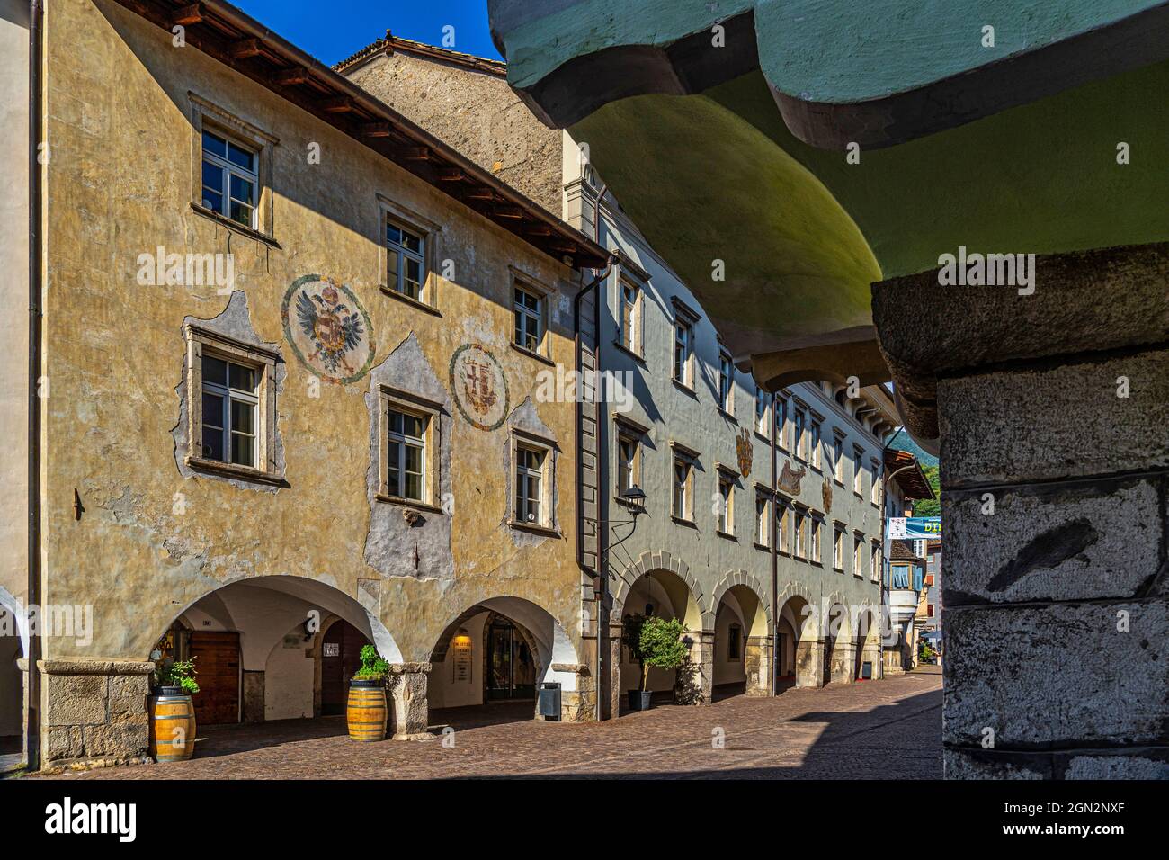 Charakteristische Häuser des antiken mittelalterlichen Zentrums von Neumarkt. Die abgesenkten Arkaden und die farbigen Fassaden sind charakteristisch für dieses Dorf. Stockfoto
