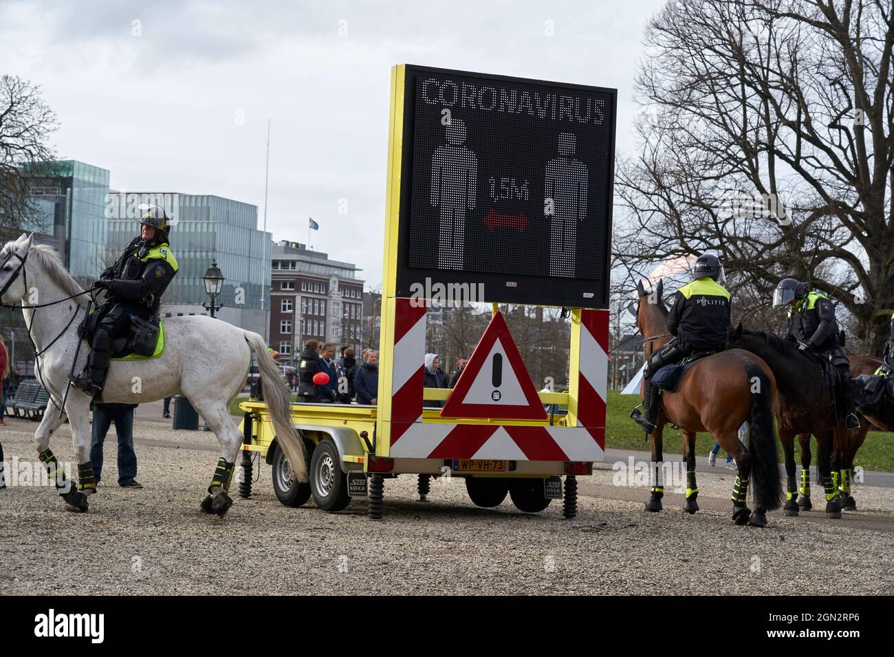 Die Polizei auf dem Pferderücken bereitet sich darauf vor, in eine Anti-Impfstoff-Demonstration einzugreifen. Stockfoto