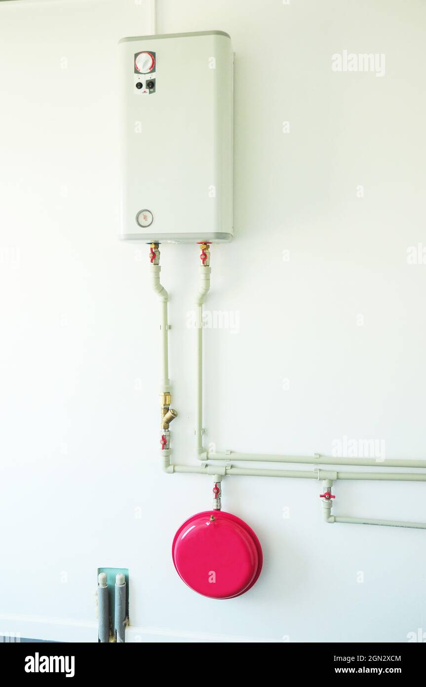 Elektrokessel mit Expansionstank zum Heizen. Haus elektrischer Warmwasserbereiter und Pipeline. Stockfoto