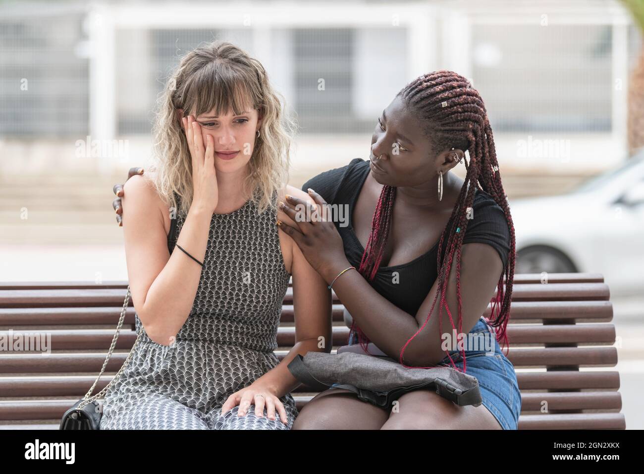 Erwachsene Frau mit beunruhigten Gesichtsausdruck, während ihr Freund sie tröstet Stockfoto