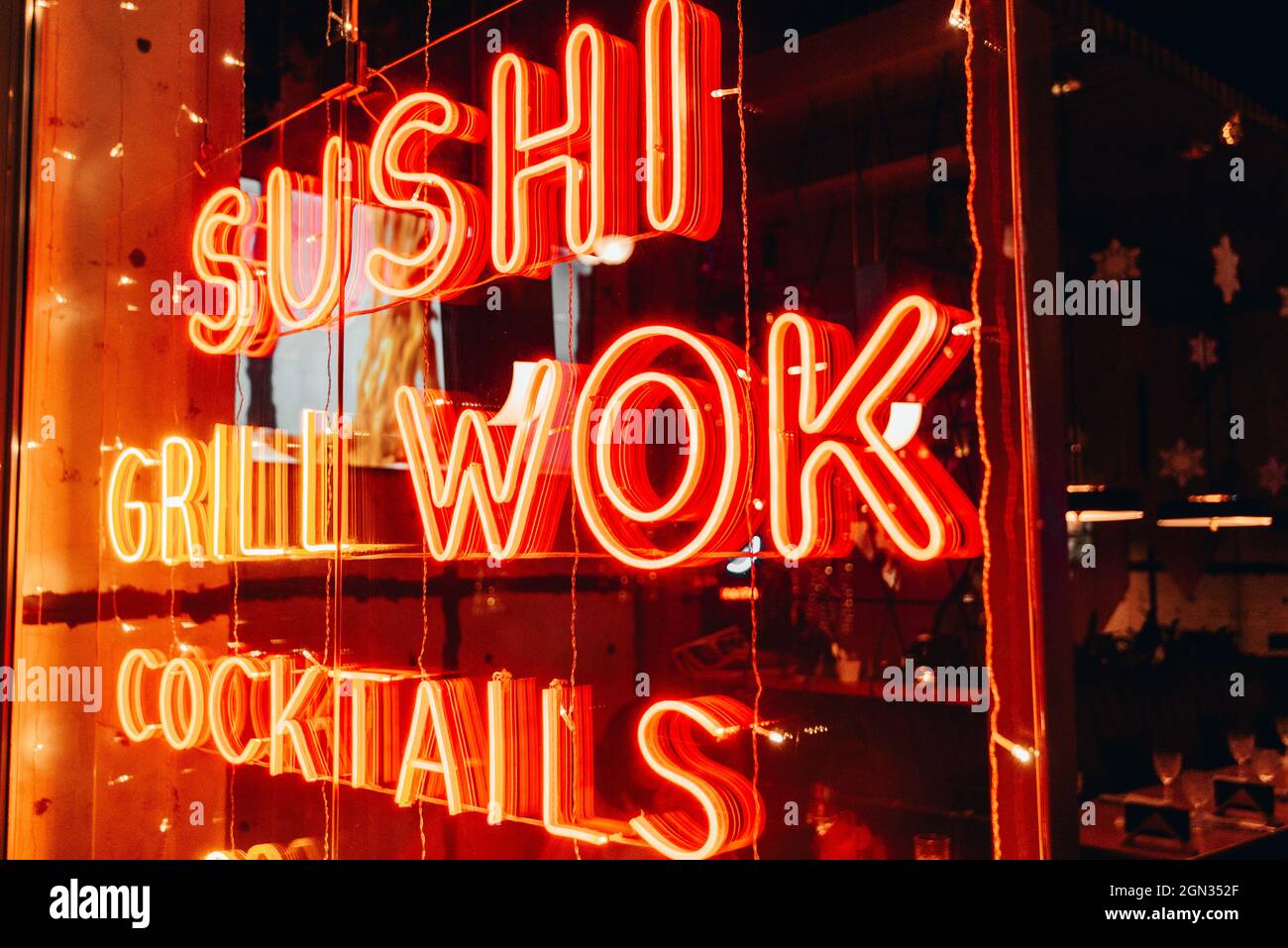 Nacht. Leuchtschilder mit dem Wort Sushi Wok Stockfoto