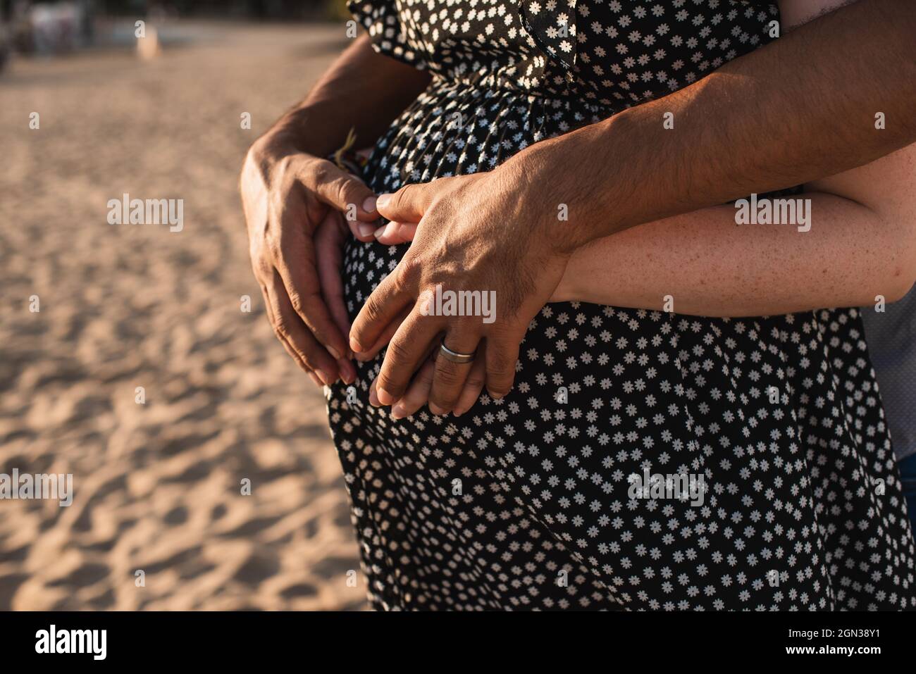 Interracial paar erwartet ein Baby. Herz mit Händen auf dem Bauch der Schwangeren. Stockfoto