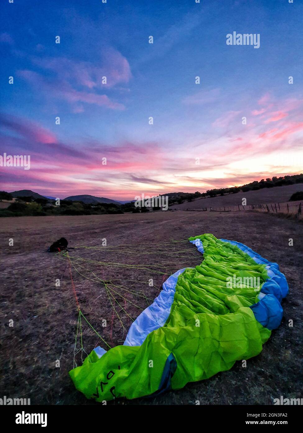 Ein Gleitschirm wurde bei Sonnenuntergang kurz nach der Landung in Andalusien, Spanien, angelegt Stockfoto