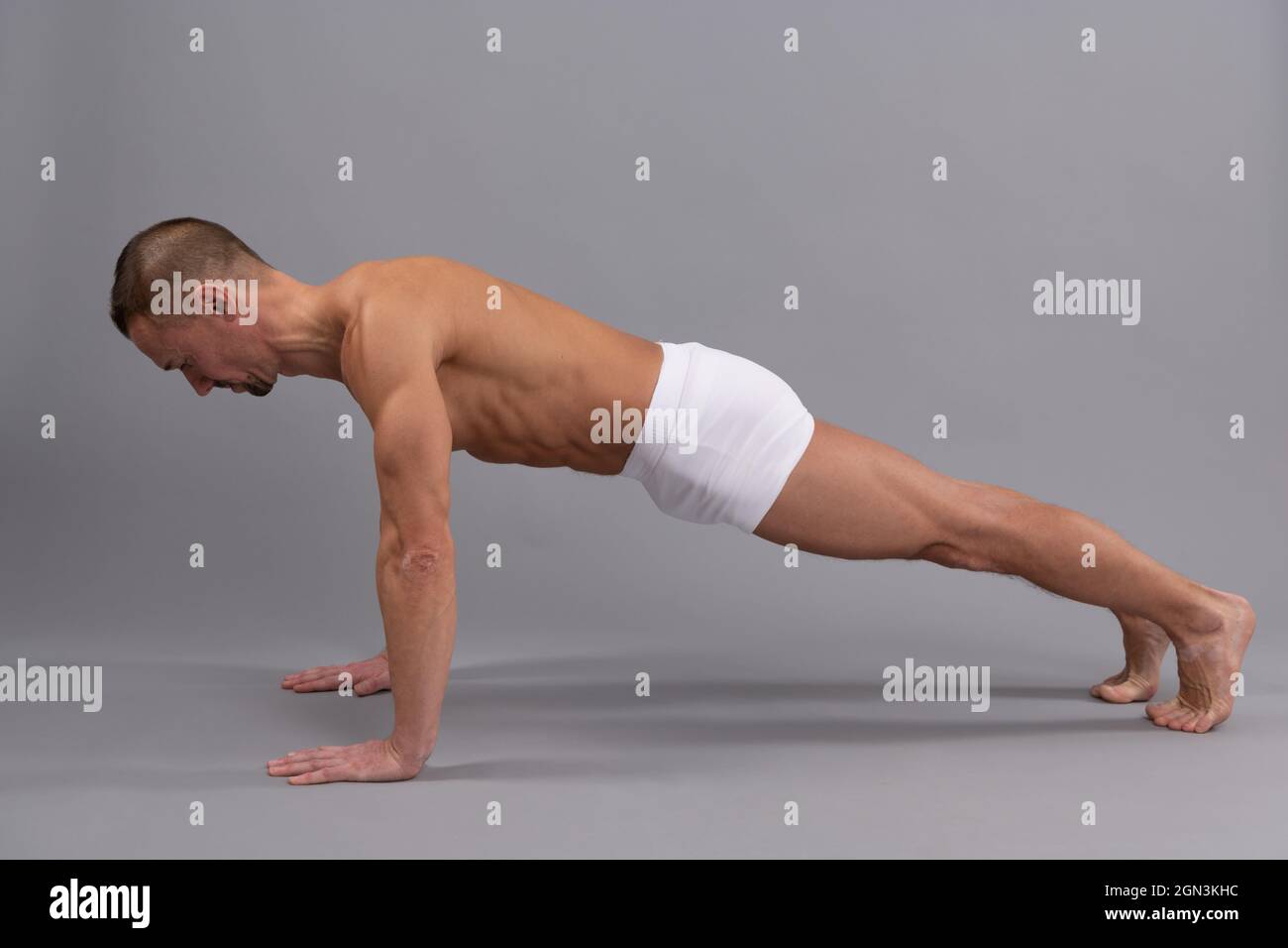 Stärkung von Armen und Wirbelsäule. Yogi-Mann macht Plank Pose. Üben von Plank Pose im Yoga Stockfoto