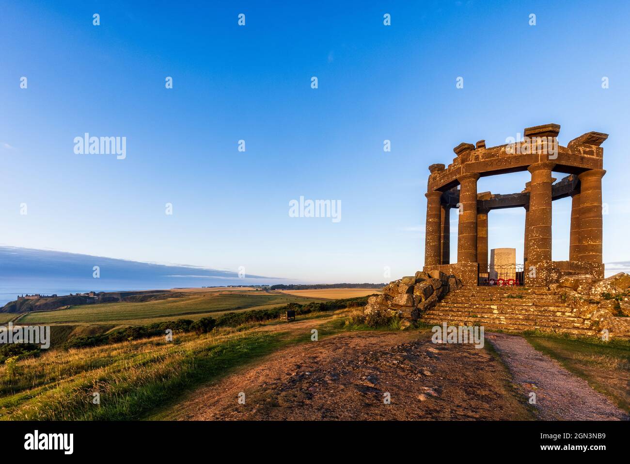 Am frühen Morgen am Kriegsdenkmal von Stonehaven, mit Dunnottar Castle in der Ferne. Das Denkmal steht auf dem Black Hill südlich der Stadt. Stockfoto