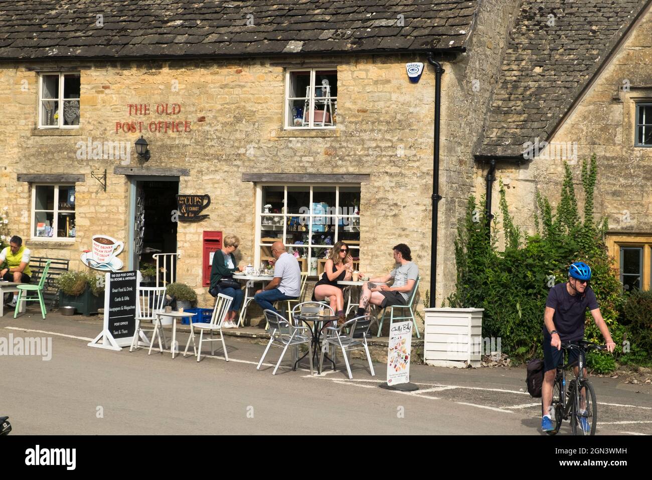 Blick auf Guiting Power, ein cotswold Village in Gloucestershire. Das Postamt und das Café. Menschen, die eine Pause einlegen Stockfoto