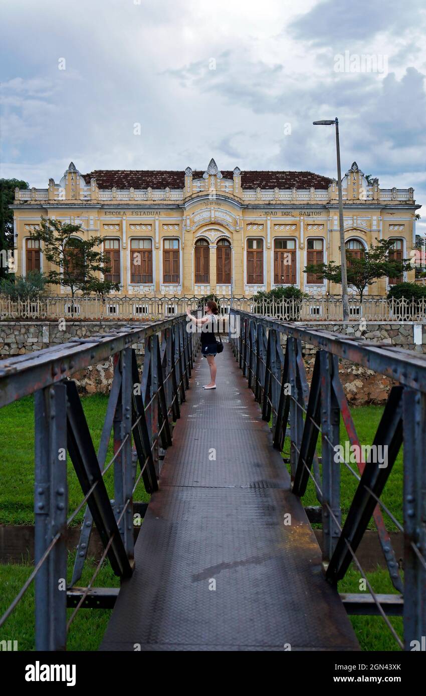 SAO JOAO DEL REI, MINAS GERAIS, BRASILIEN - 13. JANUAR 2018: Junge Frau fotografiert die historische Stadt auf einer alten Metallbrücke Stockfoto