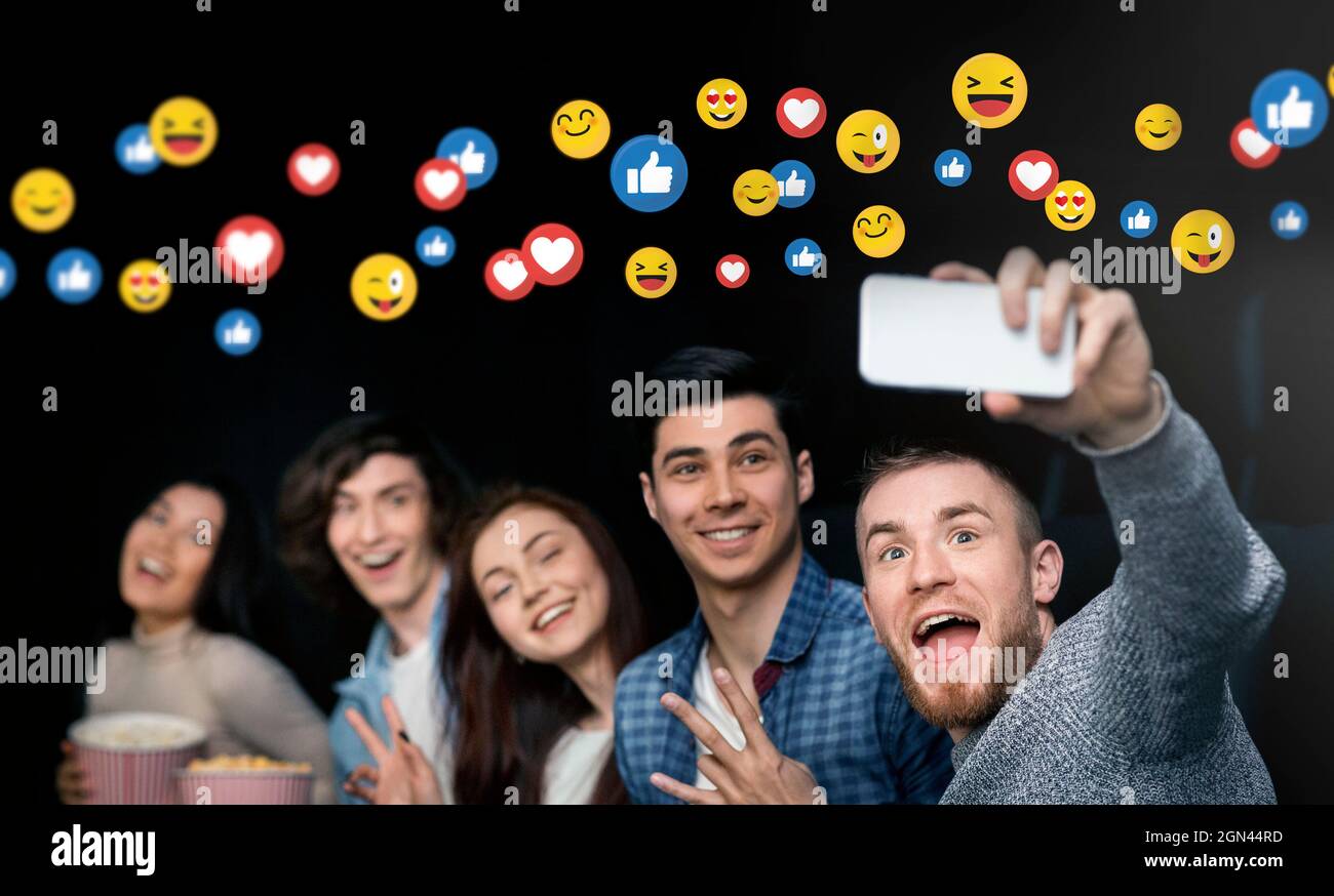 Glücklich emotional junge vielfältige Gruppe von Menschen im Kino mit Popcorn, Spaß haben, Selfie machen Stockfoto
