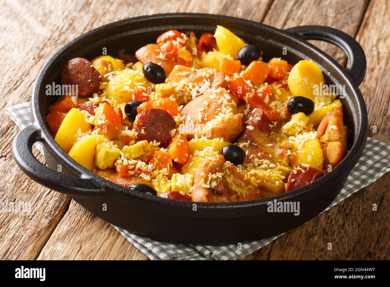 Galinha ein portugiesisches traditionelles Hühnergericht aus Macau, das in der Pfanne auf dem Tisch aus nächster Nähe serviert wird. Horizontal Stockfoto