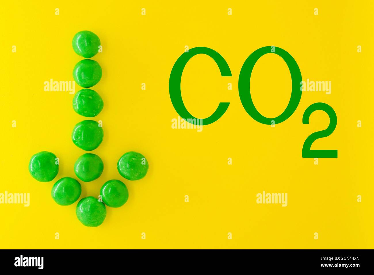 Reduzierung der Kohlendioxidemissionen und Begrenzung der globalen Erwärmung und des Klimawandels. CO2-Zeichen und grüner Pfeil nach unten Stockfoto