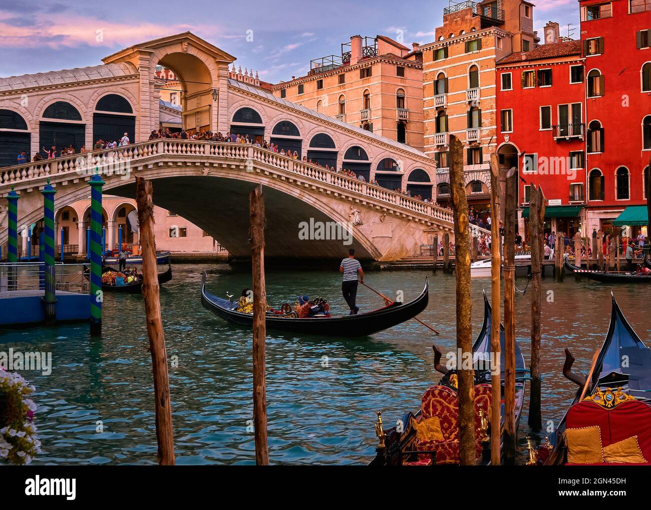Blick auf den Sonnenuntergang über der berühmten Rialtobrücke oder der rialtobrücke über dem Canal Grande, Venedig, Italien. Ikonisches Reiseziel der UNESCO-Weltkulturerbestadt Stockfoto