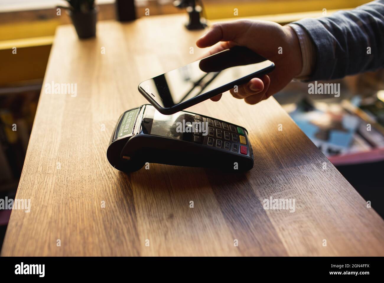 Kontaktloses Bezahlen mit Ihrem Smartphone. Bezahlen mit einem Smartphone-Gerät auf einem Kreditkartenterminal. Drahtlose Zahlung. Stockfoto