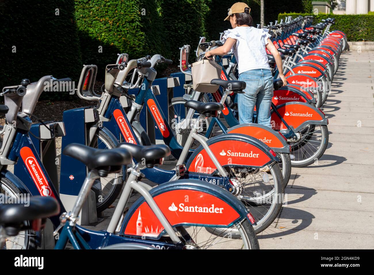 Santander fährt in einer Dockingstation in Westminster, London. Öffentliches Fahrradverleihsystem in der City of London, Großbritannien. Person, die ein Fahrrad für die Fahrt auswählt Stockfoto