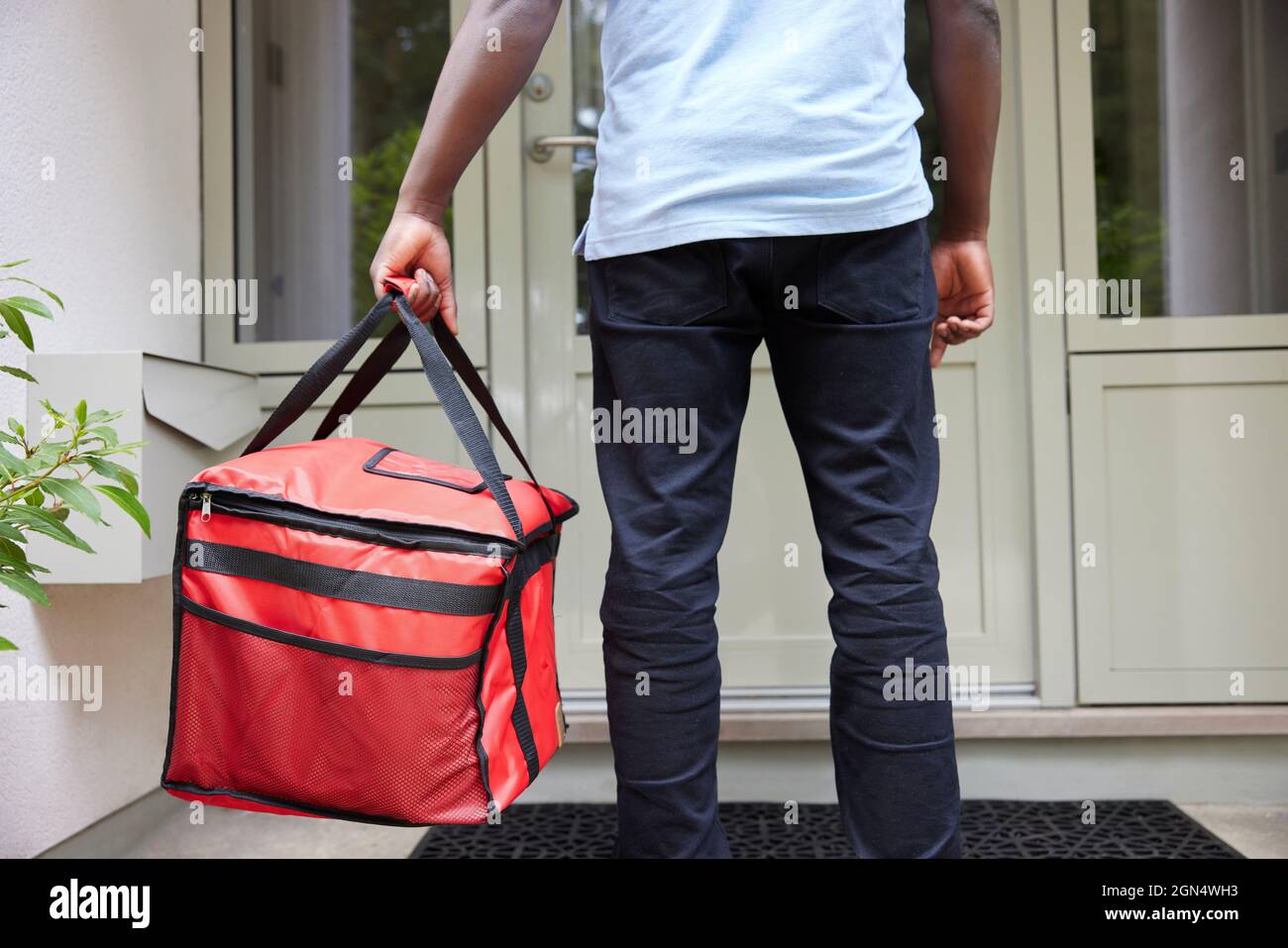 Nahaufnahme Der Rückansicht Des Gig Economy-Fahrers, Der Die Bestellung Von Lebensmitteln Im Online-Takeaway An Das Haus Liefert Stockfoto