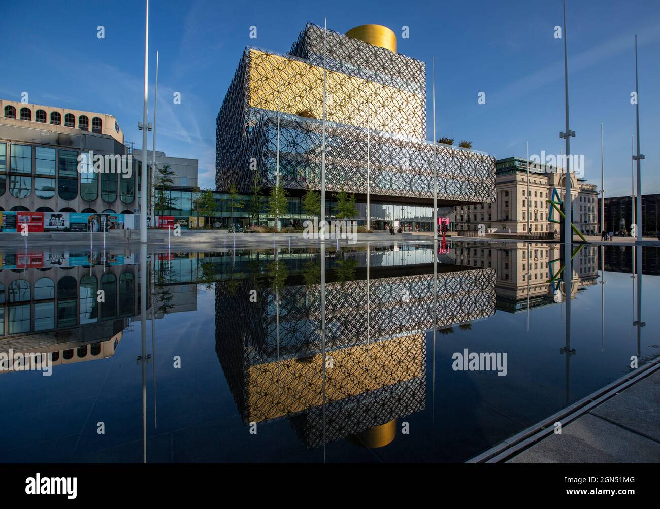 Die Bibliothek von Birmingham in der Herbstsonne spiegelte sich im Wasserspiel auf dem Centenary Square im Stadtzentrum von Birmingham, Großbritannien, wider. Stockfoto