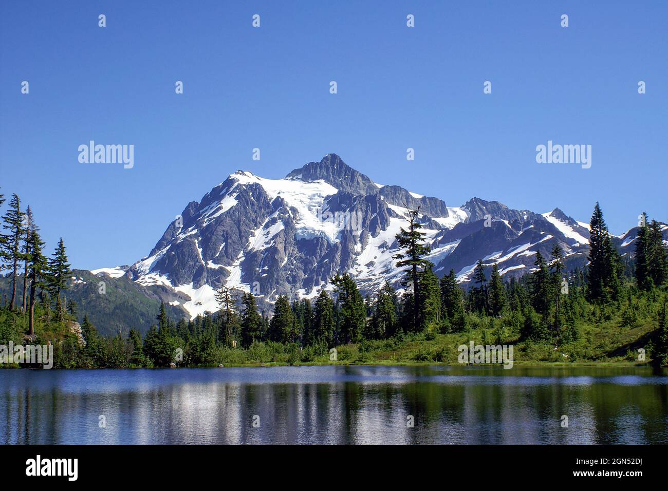 Mount Shuksan mit klarem blauen Himmel und Picture Lake. Bild See mit vergletscherten Mt. Shuksan im Hintergrund an einem wolkenlosen Sommertag Stockfoto