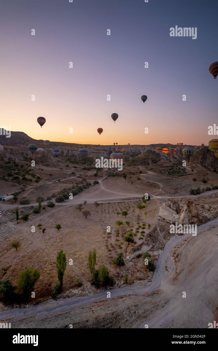 Kappadokien, Türkei - 14. September 2021: Vertikale Aufnahme von Heißluftballons, die am frühen Morgen über den goreme-Nationalpark fliegen Stockfoto